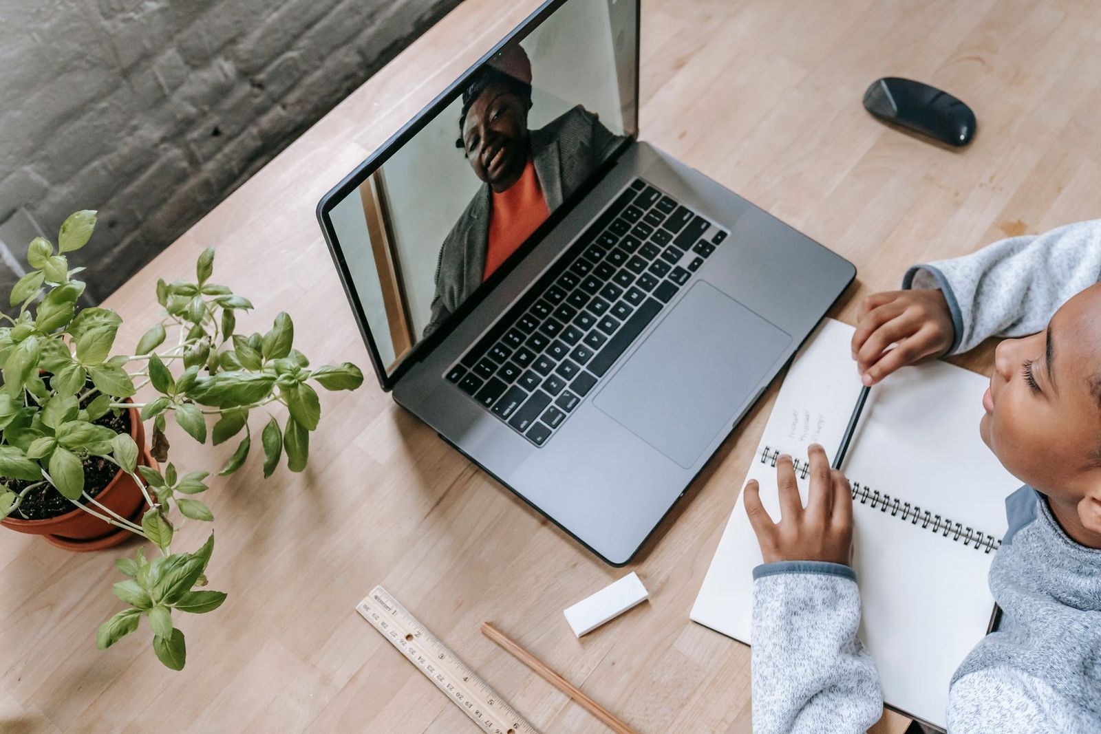 Schüler bereitet sich mit seinem Tutor per Laptop auf eine Prüfung vor, von oben
